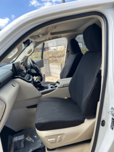 Rear seats of a 4WD fitted with black SupaFitĀ® seat covers, shown in a beige interior with seatbelt access.
