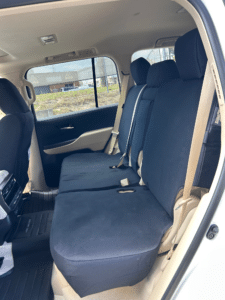 Rear seats of a 4WD fitted with black SupaFitĀ® seat covers, shown in a beige interior with seatbelt access.