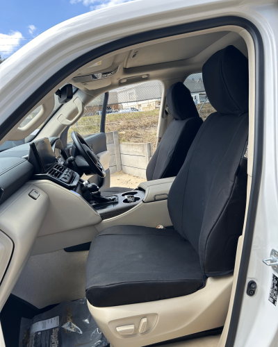 Rear seats of a 4WD fitted with black SupaFit® seat covers, shown in a beige interior with seatbelt access.