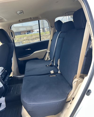 Rear seats of a 4WD fitted with black SupaFit® seat covers, shown in a beige interior with seatbelt access.
